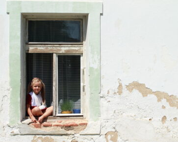 Holčička v okně - chudoba - bydlení